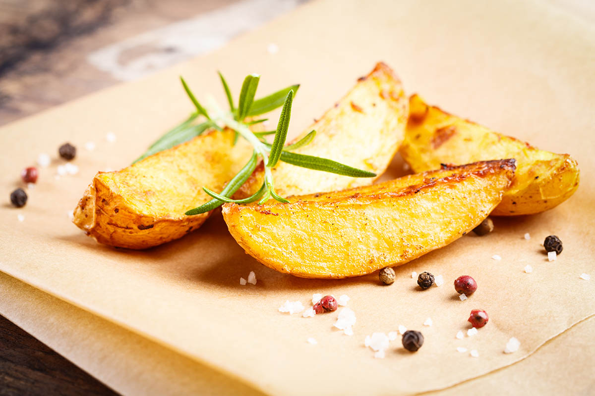 Stockfoto - Crispy fried potato wedges with rosemary